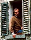 man smiling sitting on a windowsill facing outward