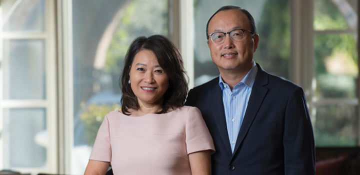 Carol and Eugene Choi stand beside each other in a well-light space