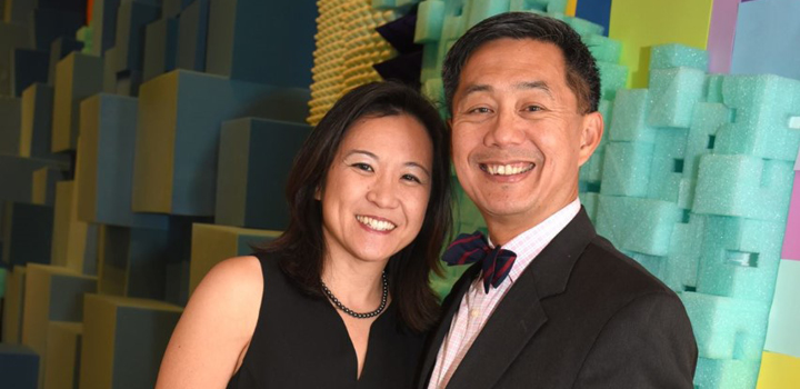 Eileen Chun-Fruto and Richard Fruto stand before a mural in formal attire