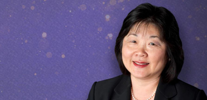 A headshot of Mary Ann Takemoto against a purple background