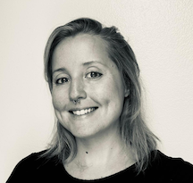 a black and white portrait of a smiling woman with a septum piercing