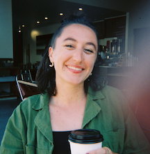 a young person wearing a green shirt smiles at the camera