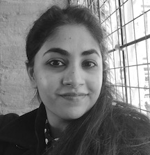 a black and white selfie of a young woman with long hair over one shoulder