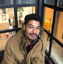 a man looks at the camera sitting on a balcony