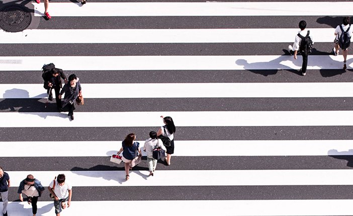 People walking across a large crosswalk