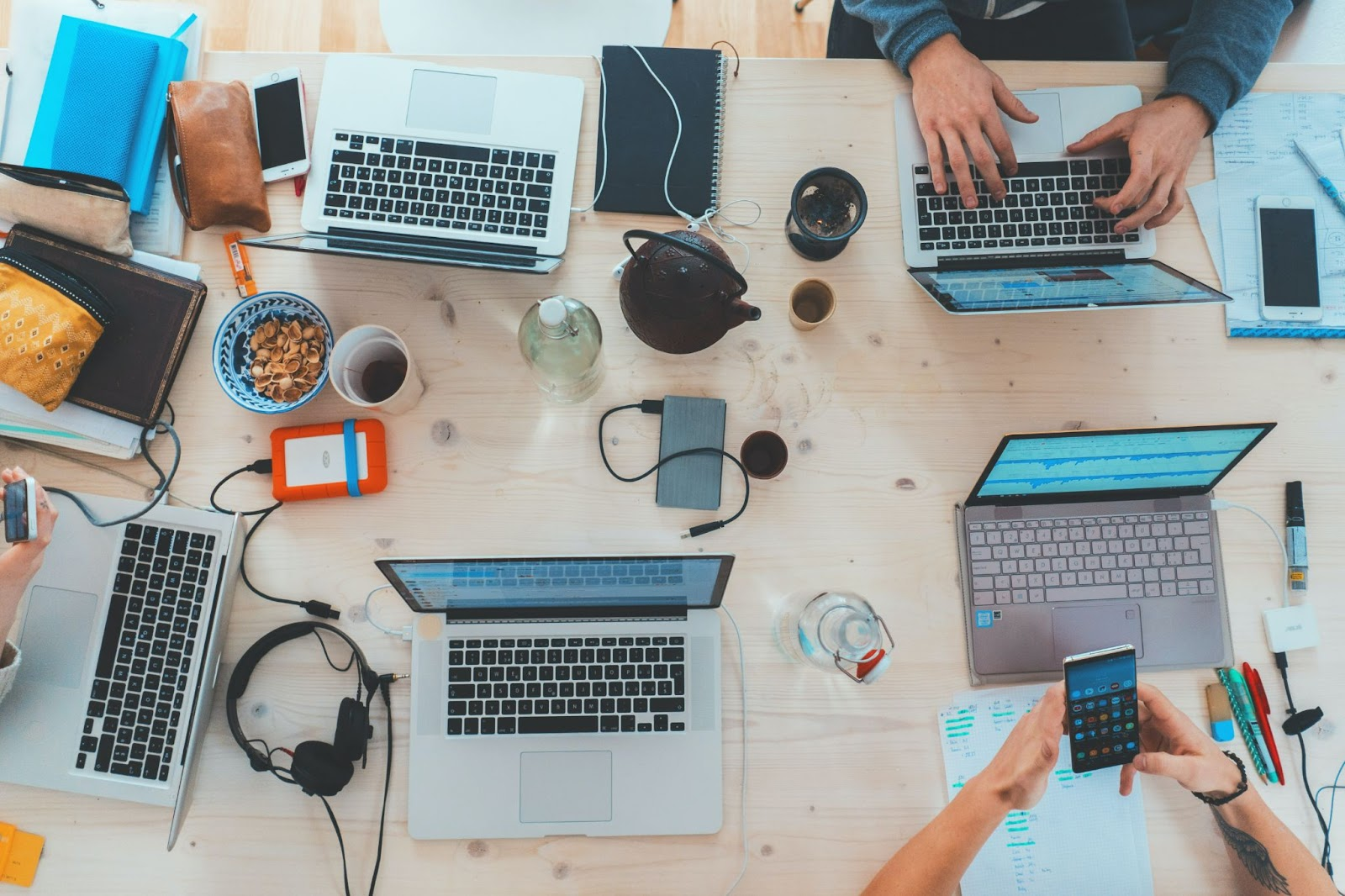 Top view down of a table with laptops and electronics laid out as students are presumed studying