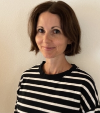 Jennifer Geraci smiling in front of beige wall