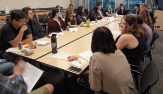 Students gathered around a table at the English Majors Association Poetry Event