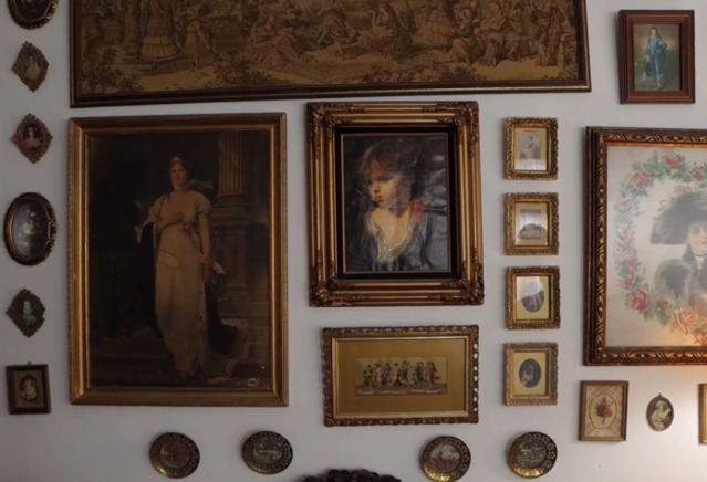 A wall full of framed art. 