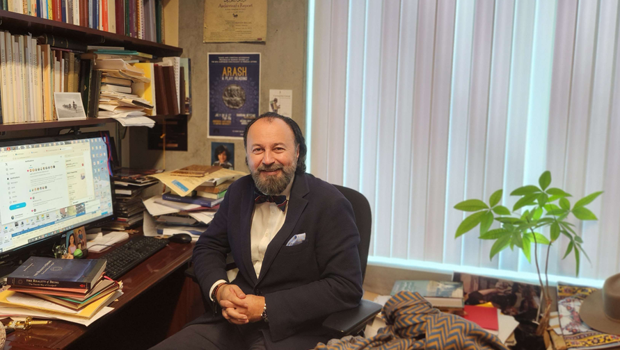 A picture of a professor in his office. 