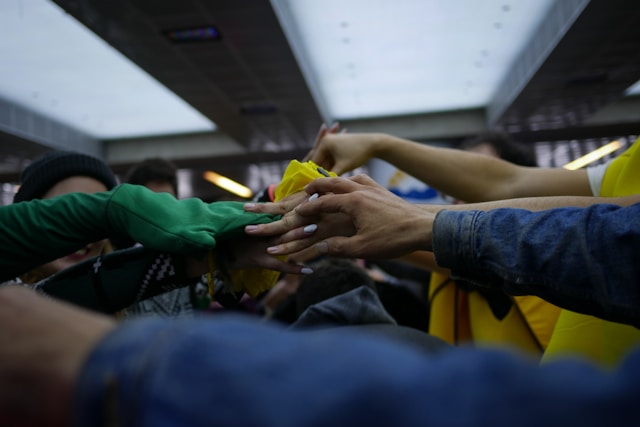 close up photo of hands reaching across to room to hold each other