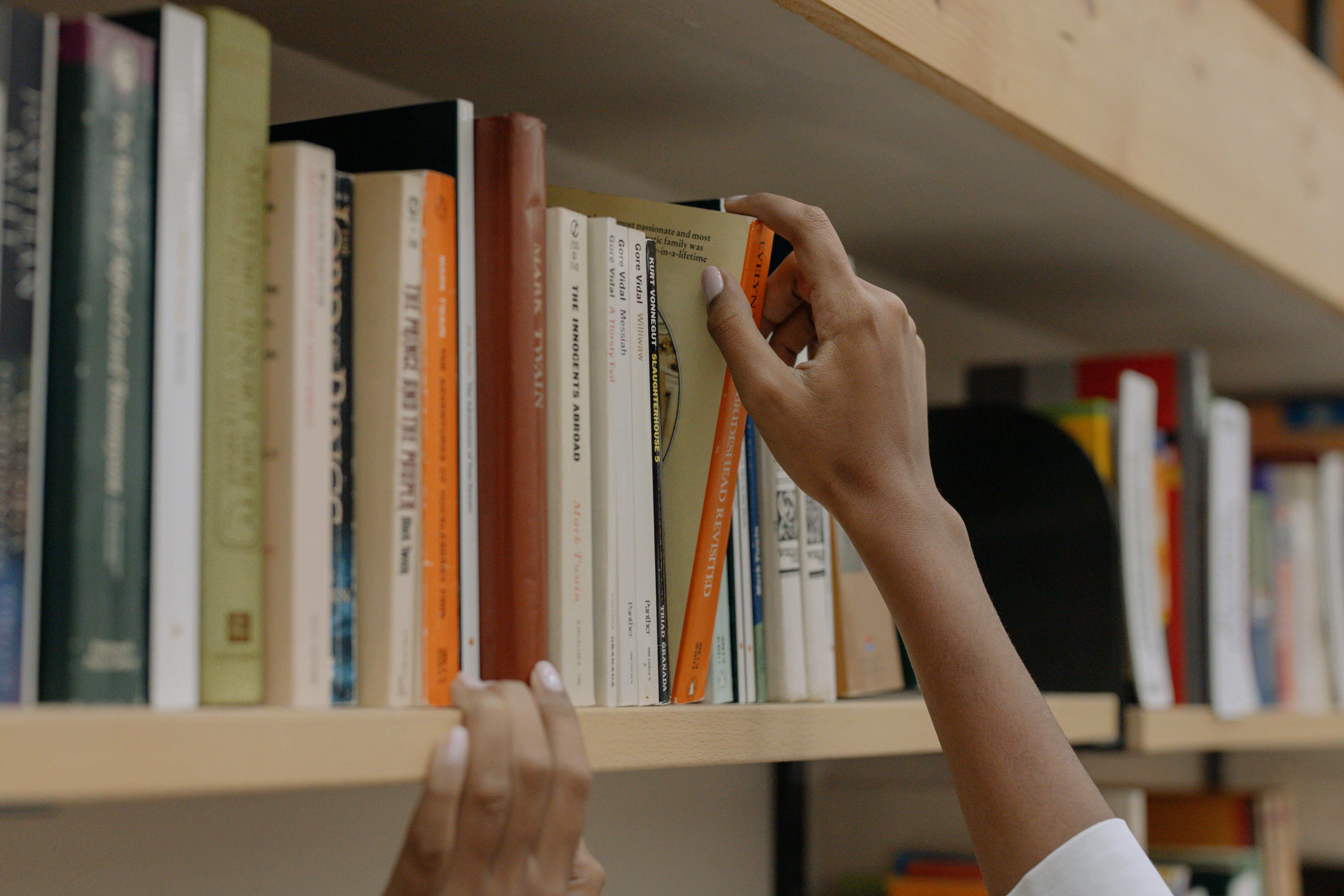 A photo of hands reaching for books