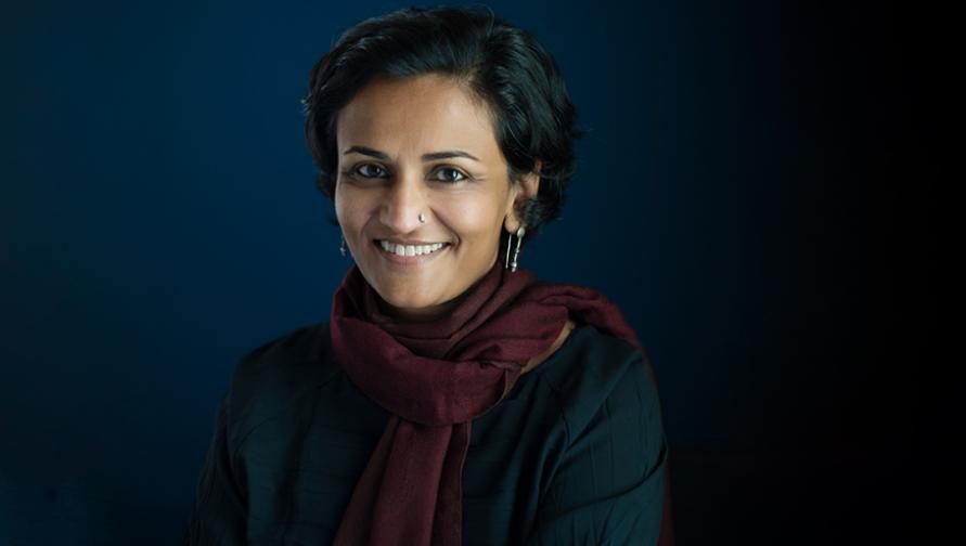Alka Patel wearing a maroon scarf and smiling at the camera