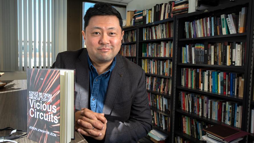 Joseph Jonghyun Jeon posing with his book "Vicious Circuits"