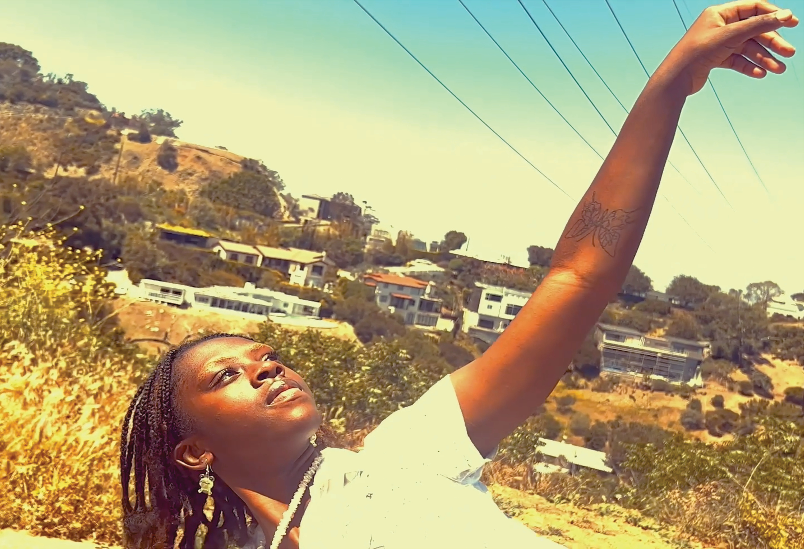 A still from the film Should I Let Go?: A woman bathed in golden light reaching towards the sky.