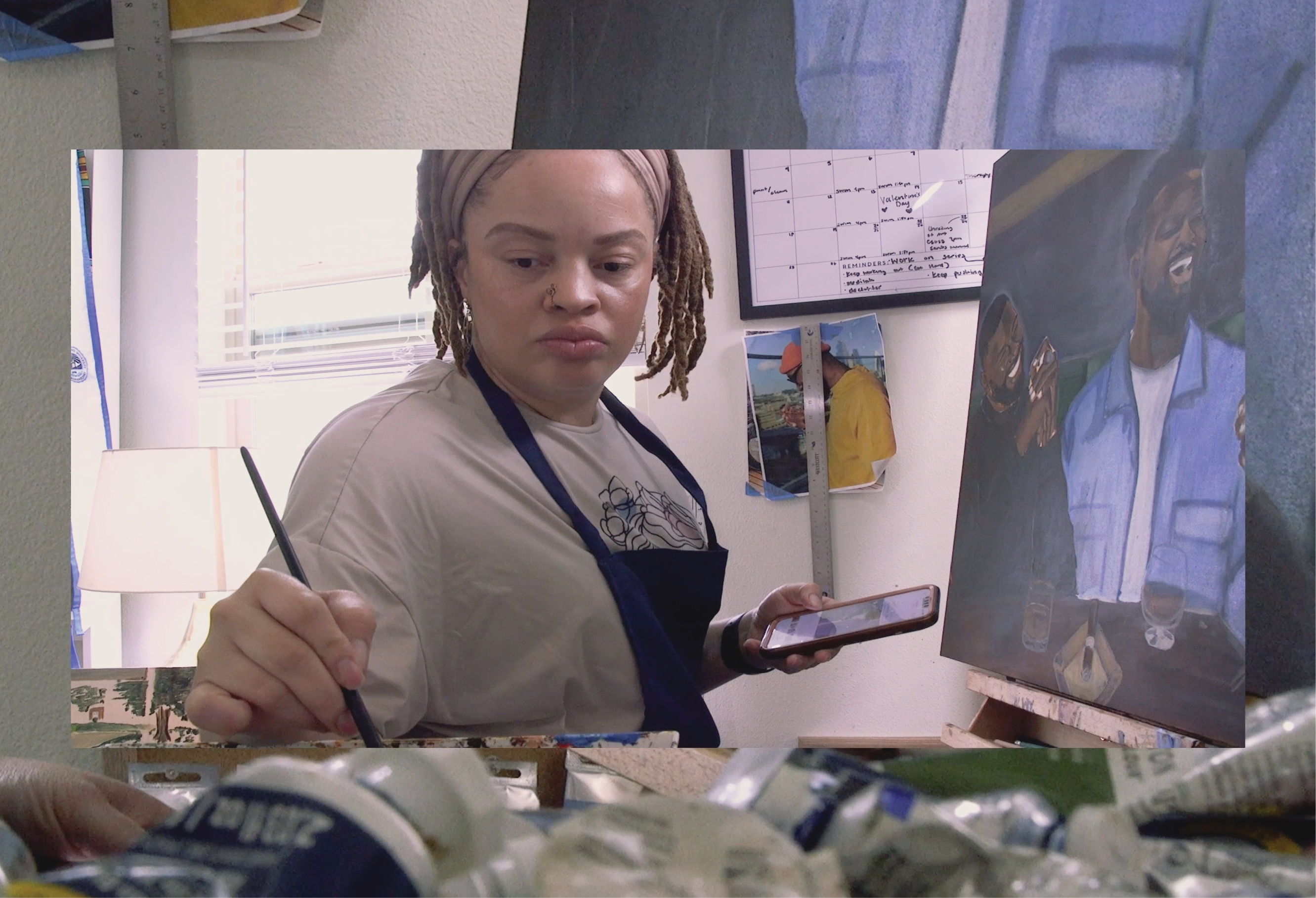 A frame from the Film Founding Space: An artist using paint on a canvas.