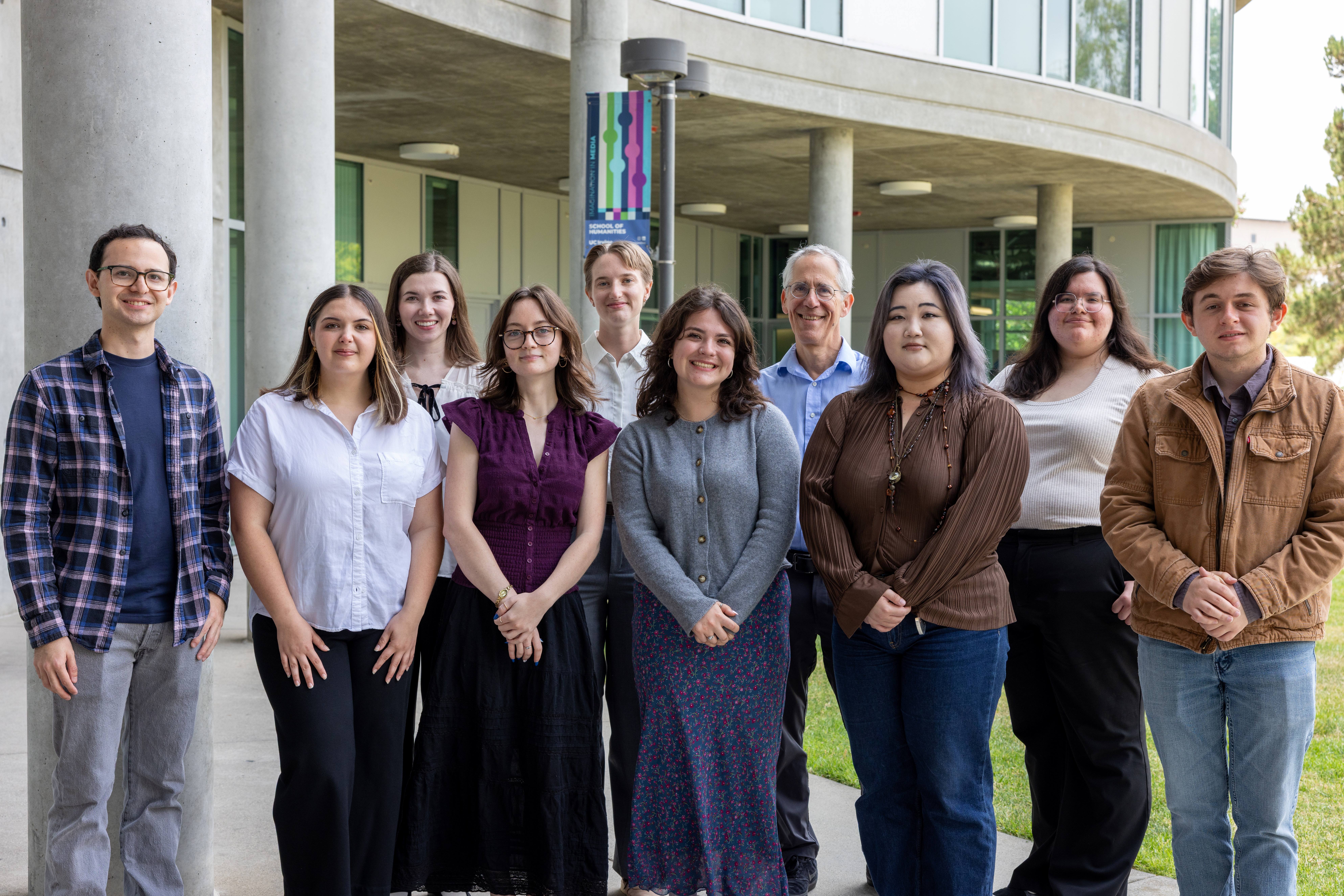 9 Humanities Honors Program students and a professor standing in front of Humanities Gateway Building