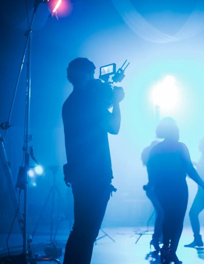A person holding a camera in a dimly lit room
