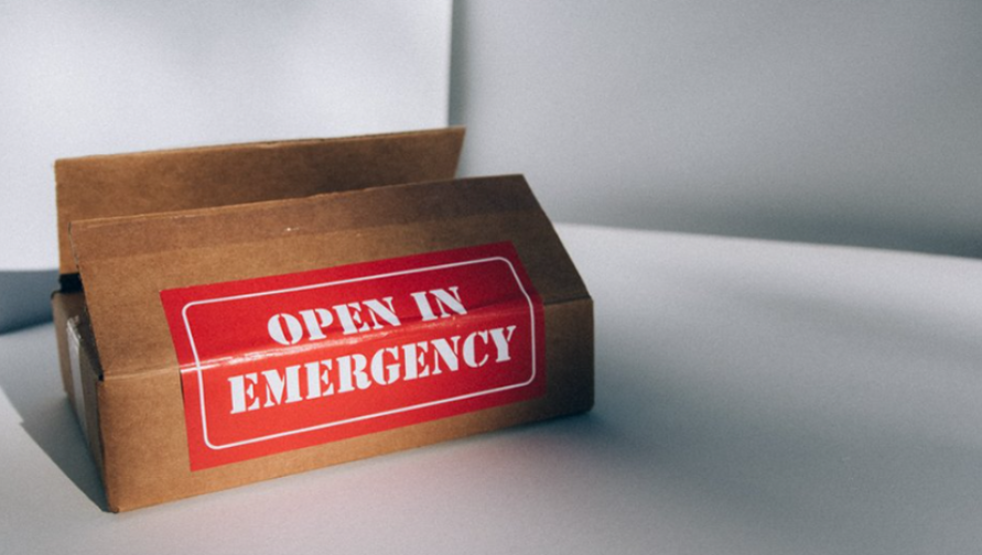 brown cardboard box with red open in emergency sticker