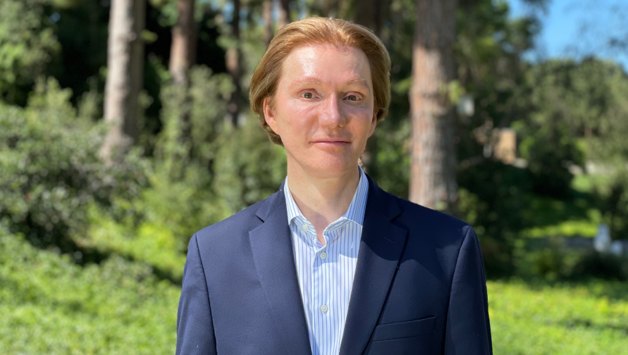 Image of man in suit with a green, nature background