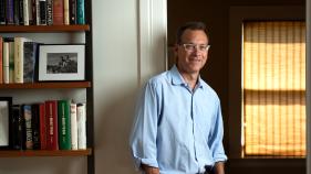 Igler stands next to a bookcase