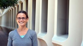 A headshot of Renée Raphael in front of Murray Krieger Hall