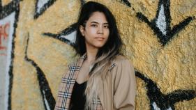 Nicole Dizon posing in front of graffiti. 