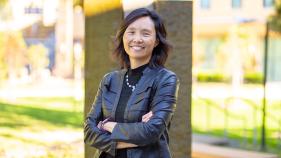 Judy Wu stands smiling in a bright, outdoor setting