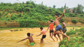 A group of boys jumping into the water.
