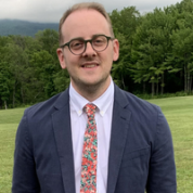 Brian Spivey smiling with trees and grass behind him