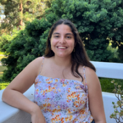 Camila Sanhueza smiling while leaning her arm against a white railing