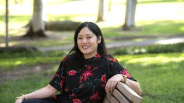 Adria Imada sits on a bench in Aldrich Park