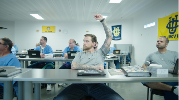 A student in the LIFTED program has his hand up in the classroom.