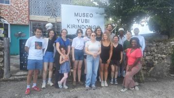 Students standing in front of an artist's studio.