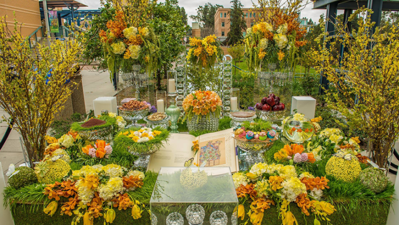 An elaborate display of flowers adorn a table set in the School of Arts courtyard