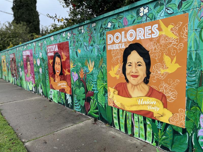 Colorful mural featuring images of activists like Dolores Huerta and Sylvia Mendez
