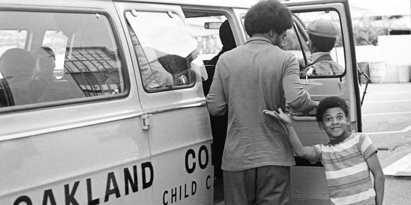 Student in front of the Oakland Community School bus.