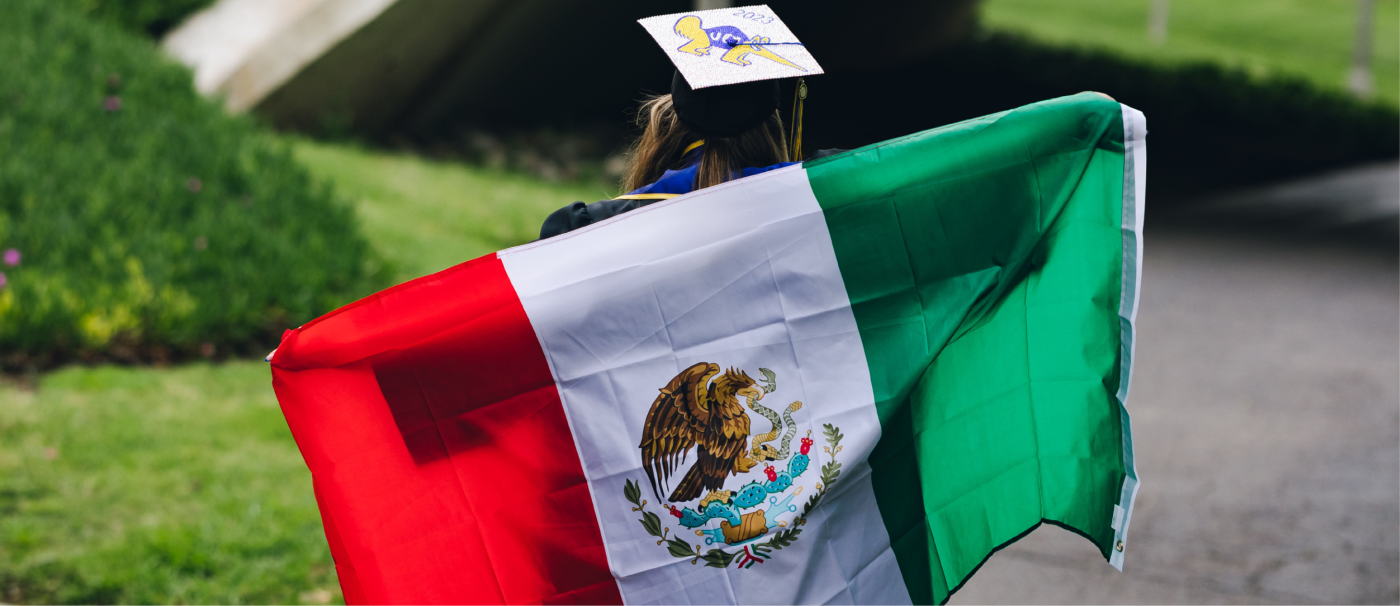 Jessica Ortiz holding a Mexican flag across her back as she walks away from the camera.