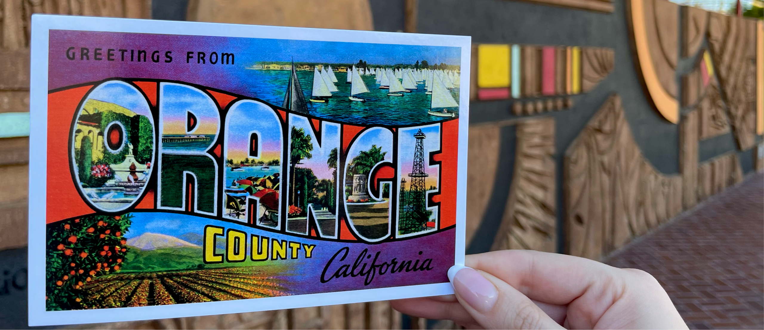 A photo of Mexican artist J. Sergio O’Cadiz Moctezuma mural with an Orange County postcard.