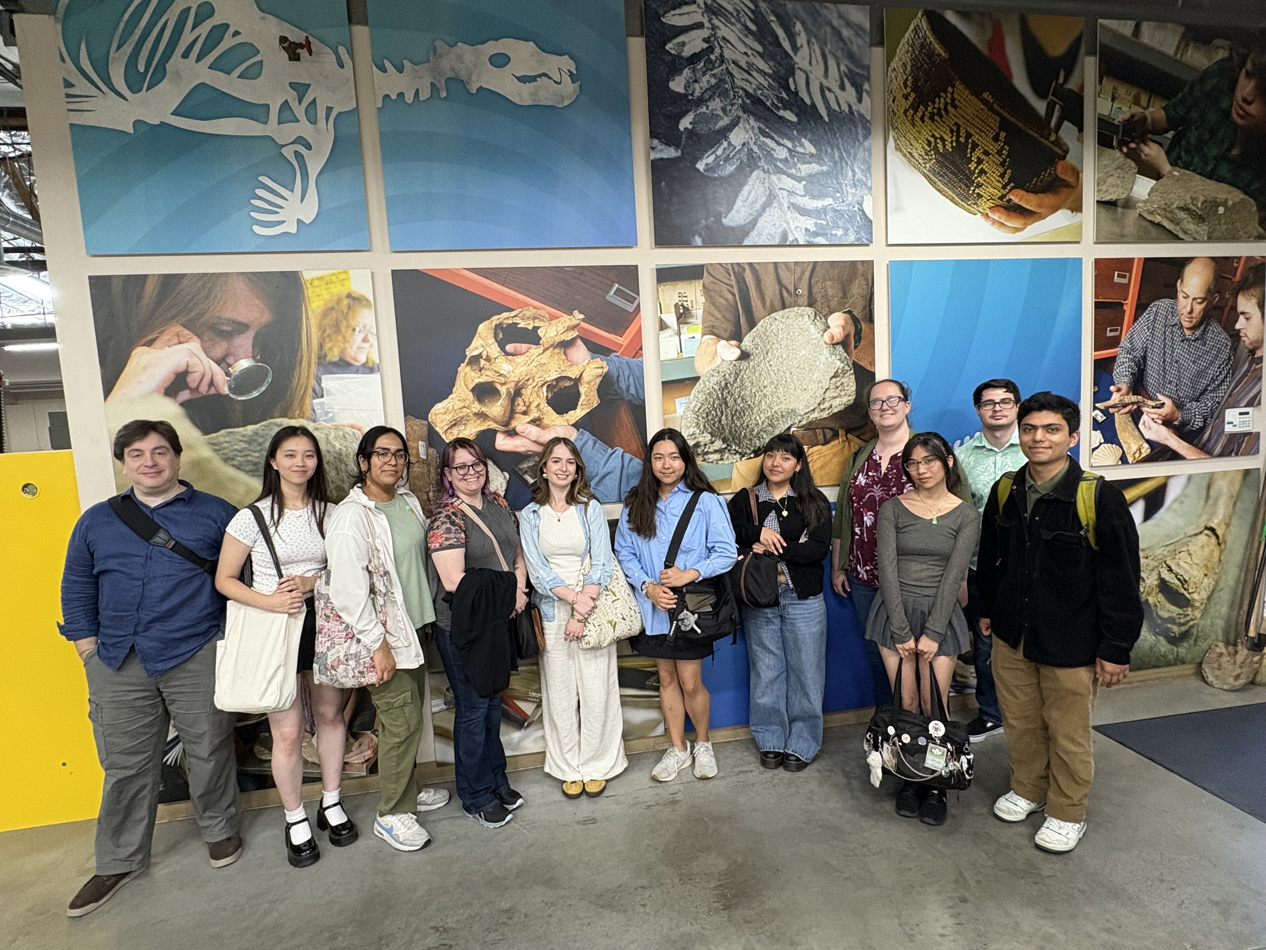 15 people stand together at OC Parks Cooper Lab with a paleontology background on Internship Touring Day.