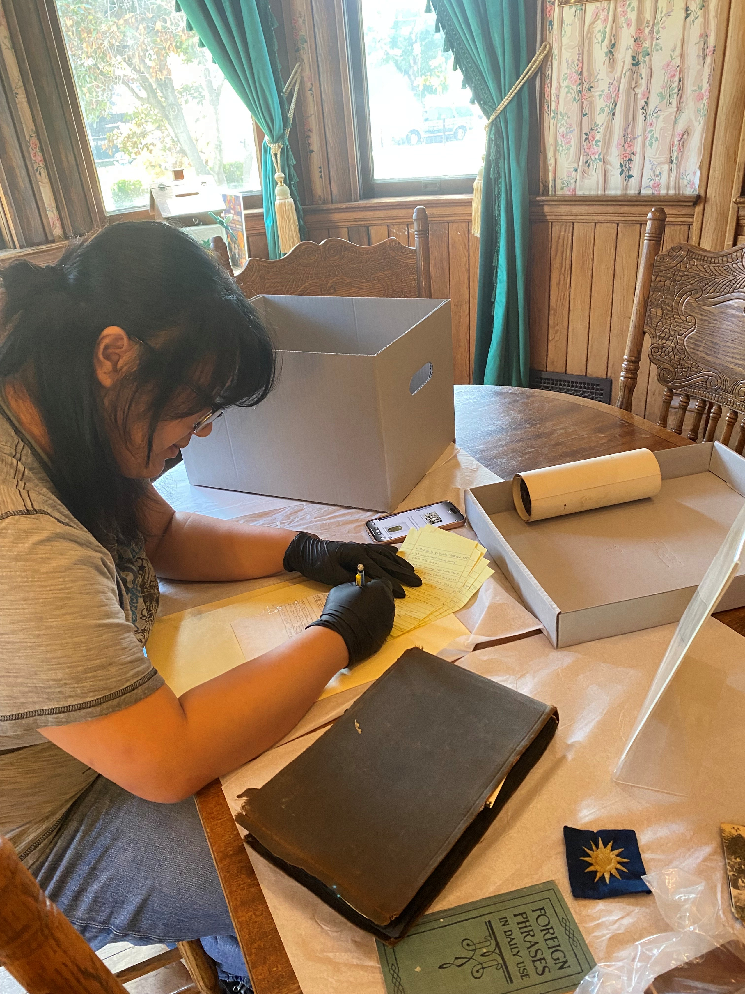 Sofia Babiera is writing some notes and doing some research on a desk.