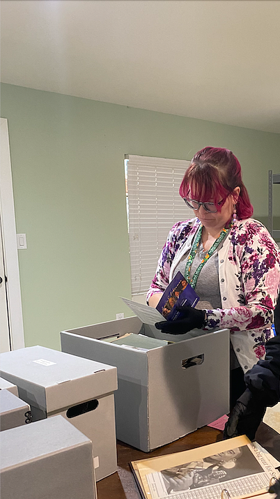 Elizabeth stands by a printer reading materials.