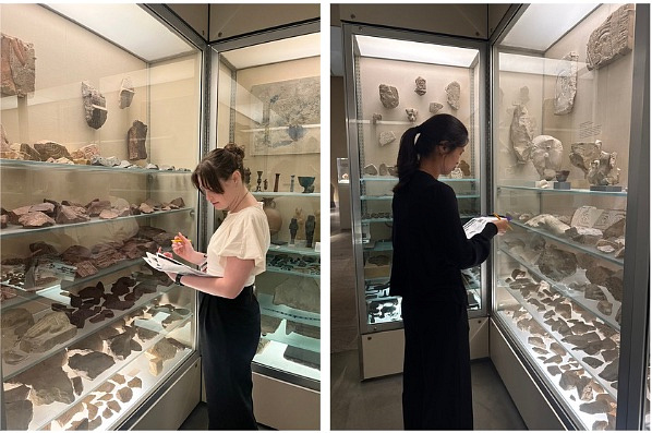 Melissa DePierro and Maddy Hua are looking at display cases and taking notes.