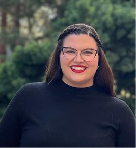 A brunette woman in a black turntleneck smiling.