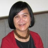 head and shoulders of smiling woman with dark hair and red cardigan