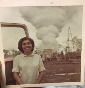 Campo Bowen's grandmother smiling at camera in front of a geothermal power plant.