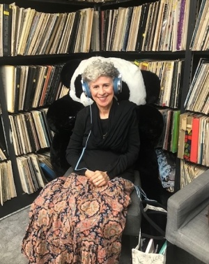 Haleema Sood smiling with headphones at the KUCI recording studio