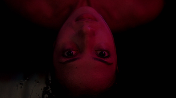 Mutable Archive - Woman laying down looking up at camera with red lighting