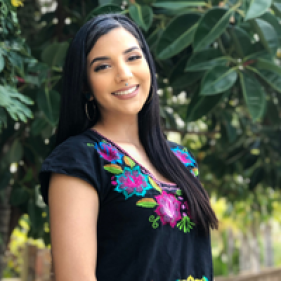 Stephanie Martinez smiling with foliage as her background