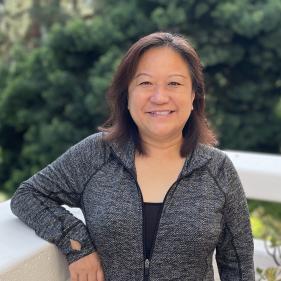 a woman smiling in a grey shirt